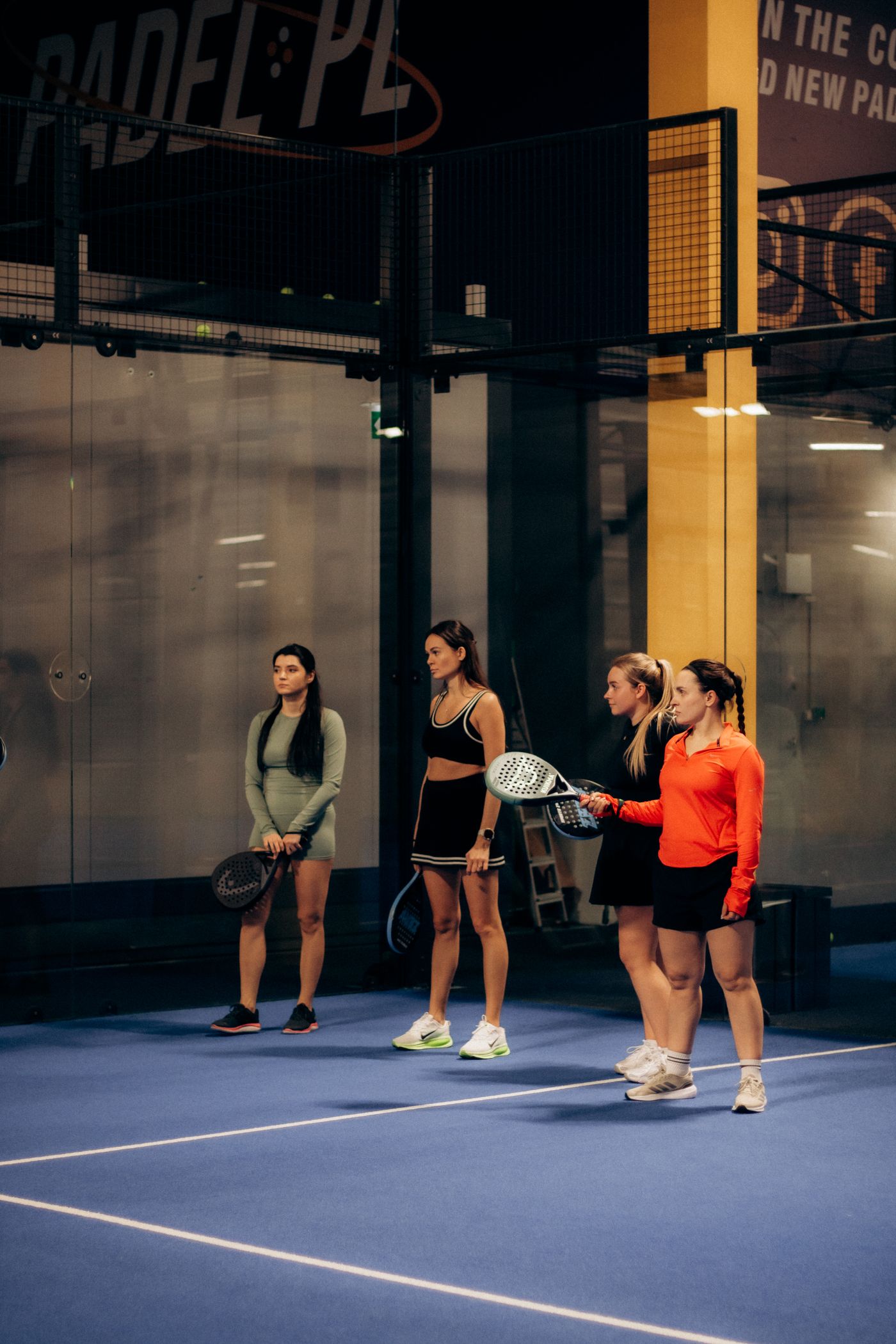 Players mid-rally on a floodlit padel court at Lekki Padel Club