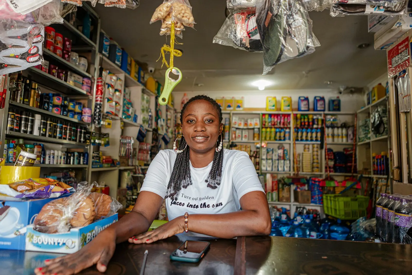 A shopkeeper standing behind the counter of her provisions shop
