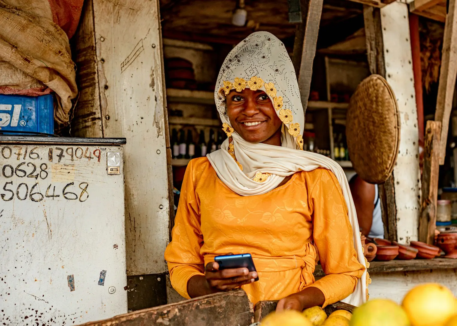 A shopkeeper in her store, phone in hand